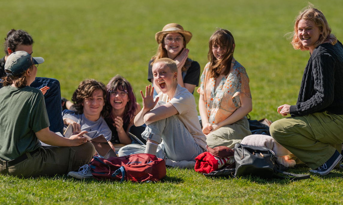A group of students sitting on the Quad on a sunny day. 